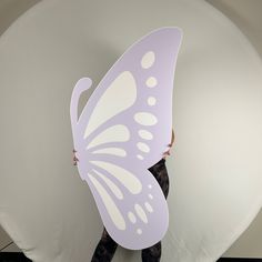 a woman holding a large white butterfly shaped cutout