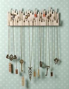 a wall mounted jewelry rack with many different necklaces hanging from it's sides