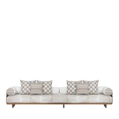 two white couches with checkered cushions and pillows on them in front of a white wall