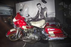 a red and white motorcycle parked next to a poster