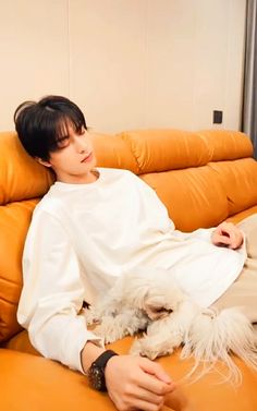 a person sitting on a couch with a dog