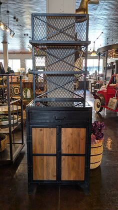 a large metal and wood cabinet sitting inside of a building next to other items on display