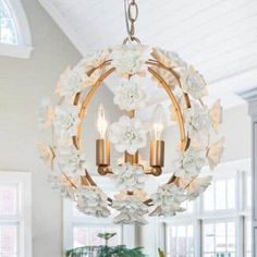 a chandelier hanging from the ceiling in a living room with flowers on it