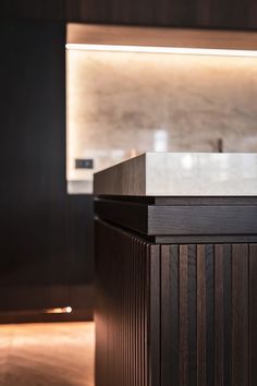 an empty counter in a modern kitchen with dark wood and white marble worktoping