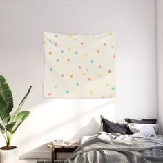 a bed room with a neatly made bed and a potted plant