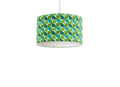 a green and blue lamp shade hanging from a ceiling fixture on a white wall background