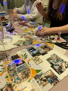 two women sitting at a table with pictures on it