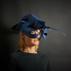 a woman wearing a blue mask and black shirt with her hair tied back to the side