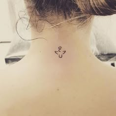 a woman's back neck with a small anchor tattoo on the left side of her neck