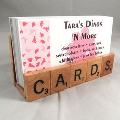 a card holder made out of scrabble tiles and wood blocks with words that spell the word cards