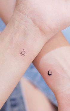 two small wrist tattoos with the sun and moon on them