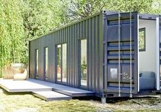 a large metal container sitting on top of a grass covered field in front of trees