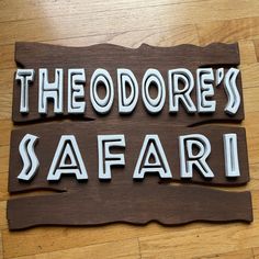 the words theodore's safari are cut out of wood and placed on a wooden floor