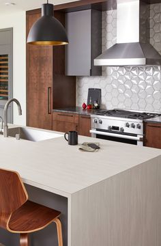 a modern kitchen with stainless steel appliances and wood cabinets, along with an island in the middle