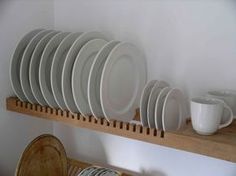 there are many plates and cups on the shelf