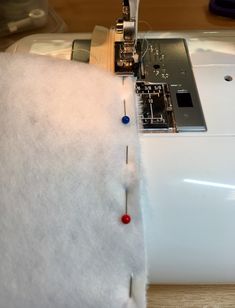 the sewing machine is being sewn on to the white piece of fabric that has been stitched together