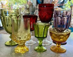 several different colored glasses sitting on top of a table