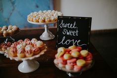 there are many different desserts on the table and one has a sign that says sweet, sweet love