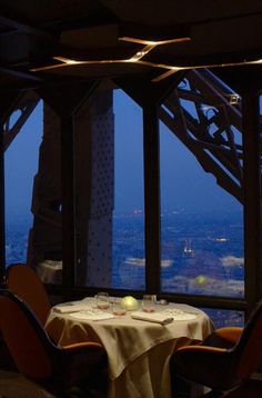 a dining table in front of a large window overlooking the city