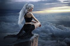 a woman with long white hair sitting on top of a cliff in the sky above clouds