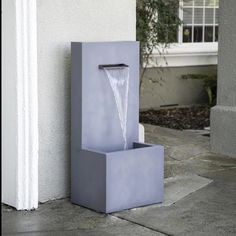 a water fountain sitting on the side of a building