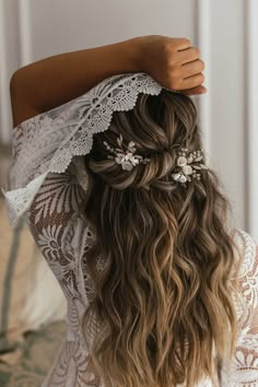 the back of a woman's head with long hair and flowers in her hair