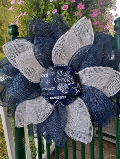 a blue and white flower on top of a fence