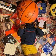 a young boy laying on top of a bed covered in lots of books and posters