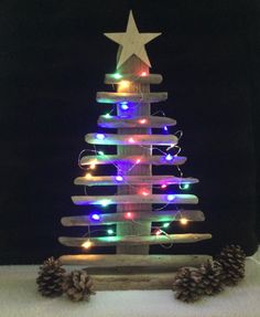 a small wooden christmas tree with lights on it