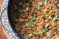 a pot filled with rice and meat on top of a wooden table