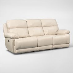 a white leather reclining sofa with pillows on the armrests and head rest