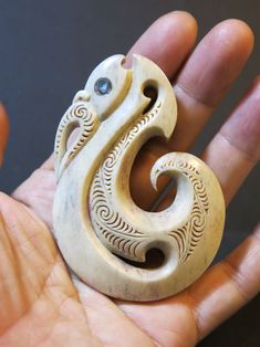 a hand holding a small carved wooden animal