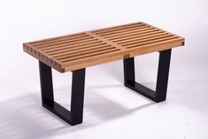 a wooden bench with black legs and slatted design on the top, against a white background