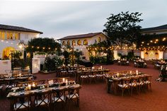 an outdoor dining area with tables and chairs set up for formal function at night time