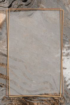 an empty square frame sitting on top of a marble slaby surface with gold trim