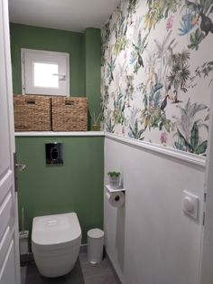 a white toilet sitting in a bathroom next to a green wall