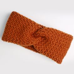 an orange knitted headband with a knot