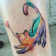 a colorful cat tattoo on the leg