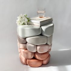 a stack of rocks with a book and flower on top sitting next to each other