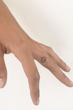 a person's hand with a small tattoo on it