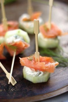 small appetizers with toothpicks and smoked salmon are on a brown plate