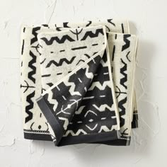 two black and white towels folded on top of each other, one with an abstract design