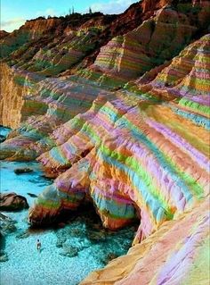 the colorful cliffs are next to the water