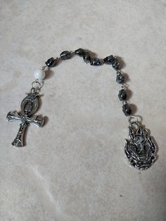 This is a deluxe version of my beautiful handmade single decade Ankh rosary. It is a stunning example of faith-inspired craftsmanship. The rosary is made with high-quality materials, including hematite beads and a scrub beetle coin pendant and finally a large white bead. ⚬ Free shipping on all orders $35 or above ⚬ If you want to buy more than one of the same rosary, message the store for special rates if supply allows.  ⚬ Each piece is handmade ⚬ Made in the USA. ⚬ More in our shop: https://www Handmade Spiritual Rosary, Ankh Rosary, Metal Storage Box, Storage Box With Lid, Clear Window, The Rosary, Metal Storage, Hematite Beads, Metal Box