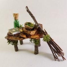 a miniature table made out of branches and twigs with a knife on it, surrounded by other items