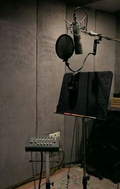 an empty recording studio with microphones and sound equipment in front of a gray wall