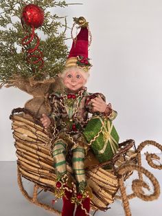 a doll sitting on top of a wicker sleigh