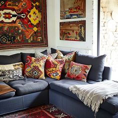 a living room filled with lots of furniture and pillows on top of a blue couch