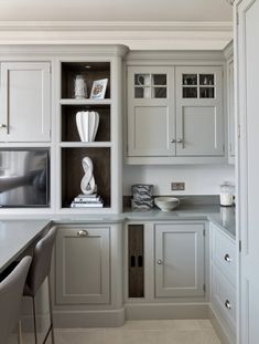 a kitchen with white cabinets and gray counter tops