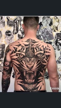 the back of a man's body with tattoos on his chest and an image of a tiger